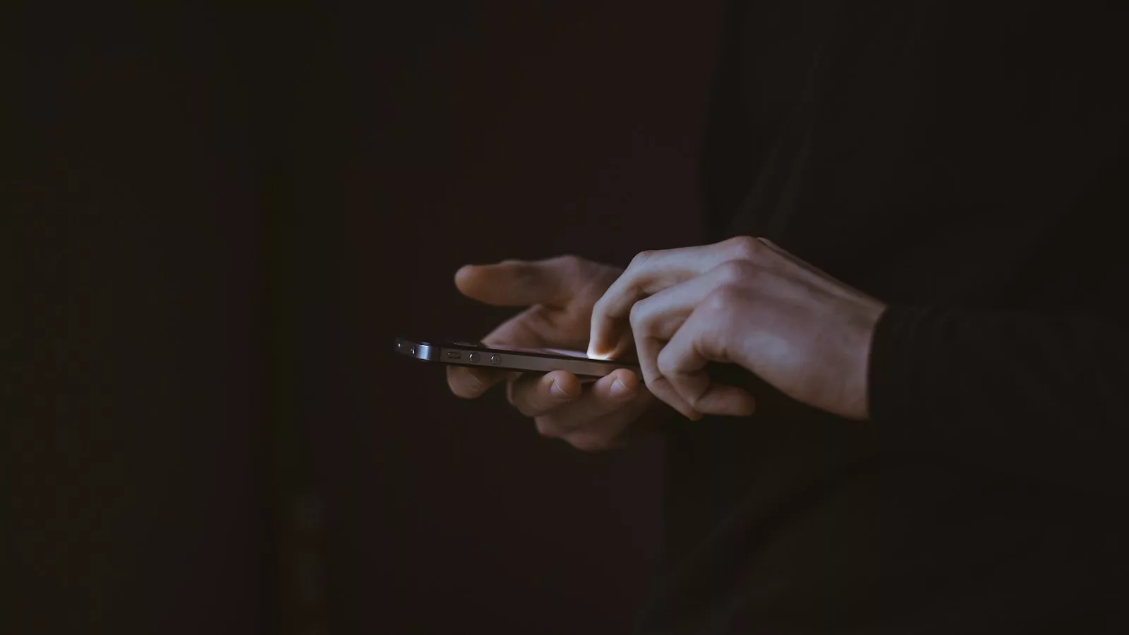 Foto de silueta d'una persona sostenint un telèfon intel·ligent