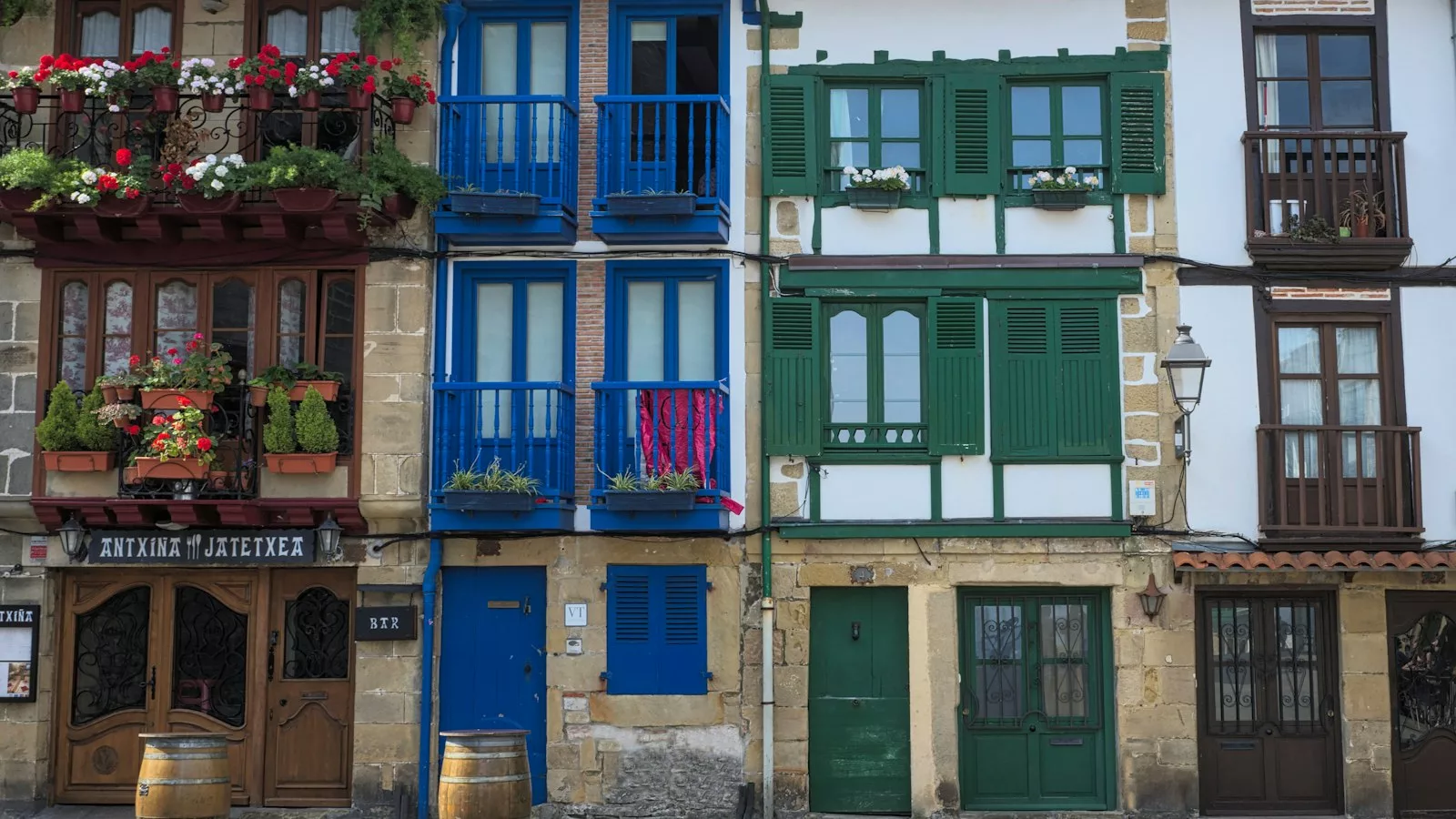 Porta de fusta blava en edifici de formigó gris